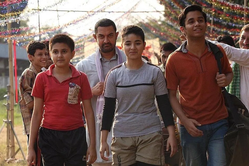 SUNTIK INSPIRASI: Aamir Khan (tengah, berjanggut) berlakon sebagai ahli gusti pesara dalam filem 'Dangal', bersama watak anak-anak perempuan yang dilatih bergusti lalu berjaya dalam arena yang lazimnya dikuasai lelaki. - Foto DANGAL