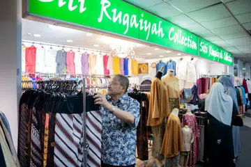 JUALAN KURANG RANCAK: Pengurus kedai pakaian Siti Rugaiyah Collection, Encik Abu Bakar Bagarib (gambar), berkata perniagaannya sejak berpindah ke City Plaza dari Tanjong Katong Complex merosot kira-kira 50 peratus. 