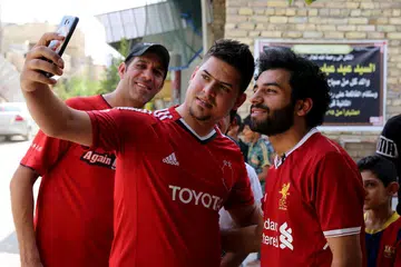 JADI 'BURUAN' PEMINAT: Hussein Ali (kanan) kerap disapa dan diminta bergambar oleh mereka yang sering keliru dan menyangka beliau merupakan bintang bola sepak Liverpool, Mohamed Salah. - Foto AFP