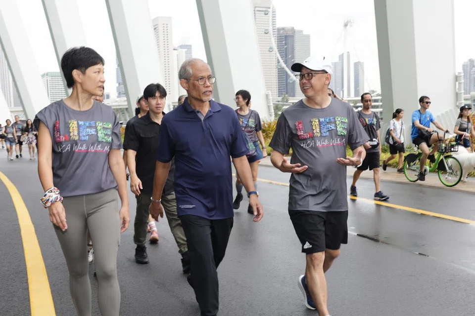 (Dari kiri) Ketua Pegawai Eksekutif (CEO) HCA, Cik Karen Lee, Menteri Pembangunan Sosial dan Keluarga, Encik Masagos Zulkifli Masagos Mohamad, dan Pengerusi Penganjur acara amal ‘Walk With Me Charity Walkathon HCA’, Encik Tay Swee Yuan berjalan di kawasan Marina Barrage. 