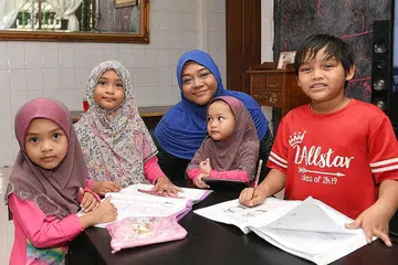 REBUT PELUANG: Cik Sulijawati bersama anaknya yang meraih manfaat daripada program Uplift, (dari kiri) Putri NurNufah Melor, lima tahun; Putri Nur Nusaibah, tujuh tahun; Putri NurNuha Flora, tiga tahun; dan Muhammad Azhar Putra, sembilan tahun. - Foto BH oleh MOHD KHALID BABA