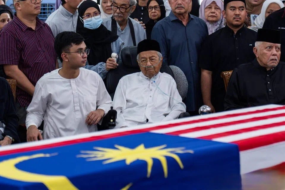 Wajah sugul mantan Perdana Menteri Malaysia, Tun Dr Mahathir Mohamad (dua dari kiri) merenung keranda menempatkan jenazah isterinya, Allahyarhamha Tun Dr Siti Hasmah Mohamad Ali, ketika pengurusan jenazah di Masjid As Syarif, Taman Sungai Besi Indah, Kuala Lumpur, pada 28 September. Masjid ini adalah masjid yang sering dikunjungi Dr Mahathir dan Dr Siti Hasmah.
