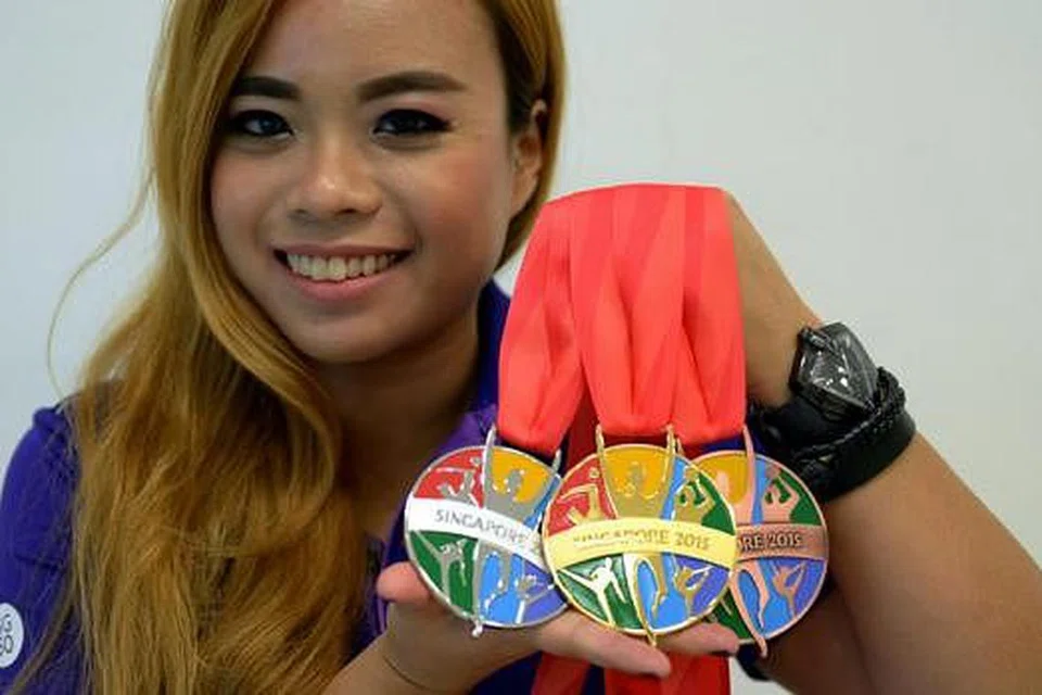 UNIK: Pereka grafik Joys Tan dengan pingat warna-warni Sukan SEA Ke-28 hasil rekaannya. - Foto ZAINAL YAHYA