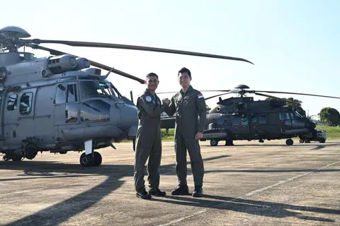Leftenan Kolonel (LTC) Lim Seng Wee (kanan), Pegawai Pemerintah Angkatan Udara Republik Singapura (RSAF), Skuadron 125 bersama Lt. Kol. Ahmad Farhan Ahmad (kiri), Pegawai Pemerintah, Tentera Udara Diraja Malaysia (RMAF), Skuadron 10 berada di hadapan helikopter RSAF H225M (belakang) and RMAF EC725 (depan) yang menyertai Latihan Search-And-Rescue (SAREX) MALSING 2024.