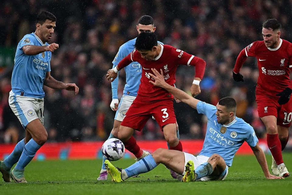 Pemain tengah Manchester City, Mateo Kovacic (dua dari kanan), dan pemain tengah Liverpool, Wataru Endo (tengah), berebut semasa perlawanan yang sengit antara dua pasukan itu di Anfield pada 10 Mac. 