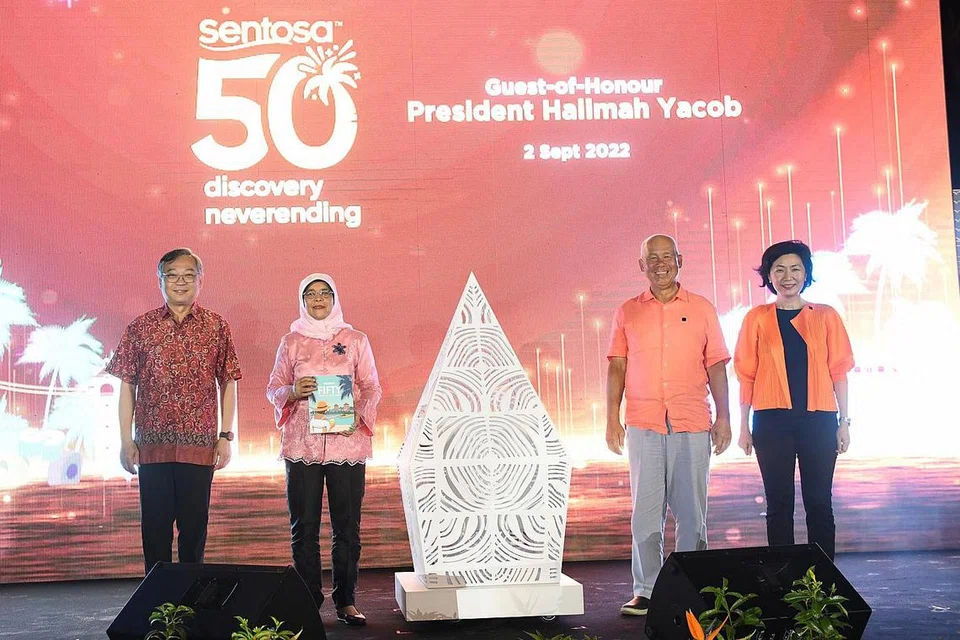 JUBLI EMAS SENTOSA: Kapsul masa sempena ulang tahun Sentosa yang ke-50 dikunci selepas Puan Halimah (dua dari kiri) memasukkan barang yang terakhir, iaitu senaskhah buku yang memaparkan kisah daripada 50 personaliti, selebriti dan pihak berkepentingan utama Sentosa di jamuan malam Jubli Emas Sentosa di Pantai Siloso baru-baru ini. Puan Halimah bersama (dari kiri) Menteri Perdagangan dan Perusahaan, Encik Gan Kim Yong; Encik Tan; dan CEO SDC, Cik Thien Kwee Eng. - Foto SDC