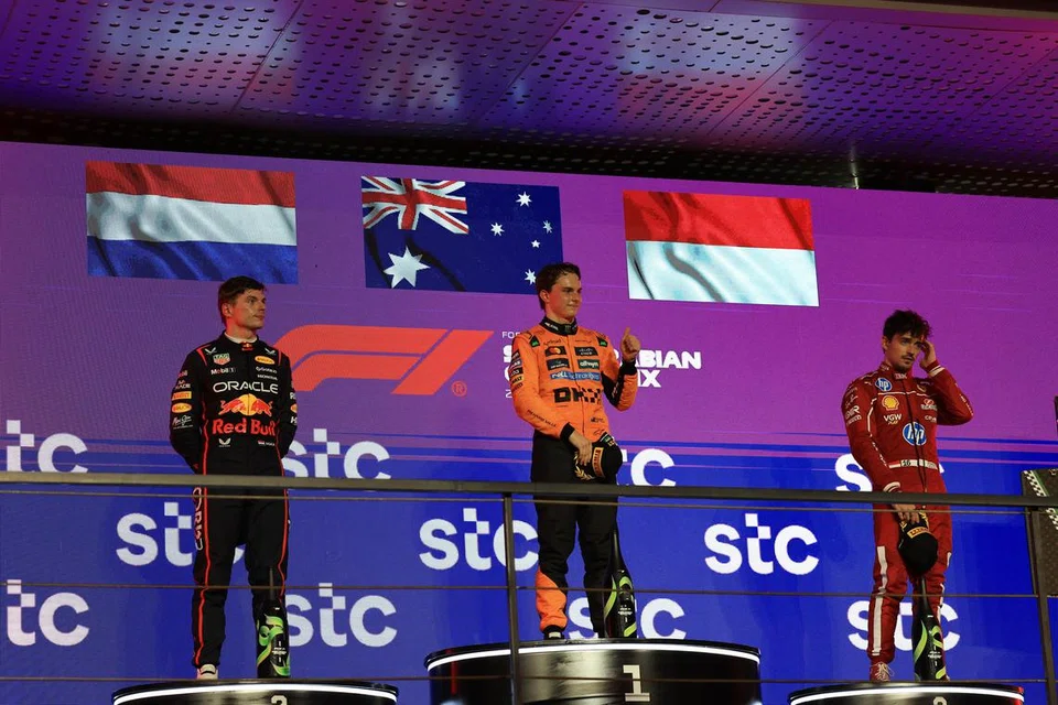 Pemandu McLaren, Oscar Piastri (tengah), meraikan kemenangan di  Grand Prix Arab Saudi. Bersama beliau ialah pemenang tempat kedua daripada Red Bull, Max Verstappen (kiri), dan tempat ketiga,  Charles Leclerc, daripada Ferrari.