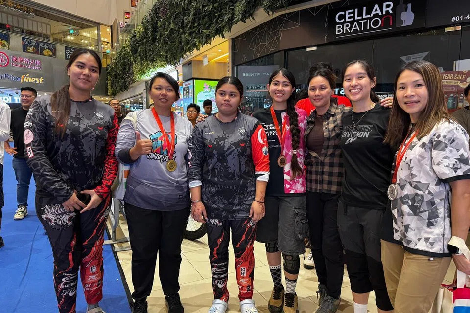 Tular di Tiktok Cik Nur Nasthasia Nadiah Abdul Nazzee (dua dari kiri) memuatnaik pengalamannya berlumba di Seletar Mall termasuk menuruni eskalator curam.