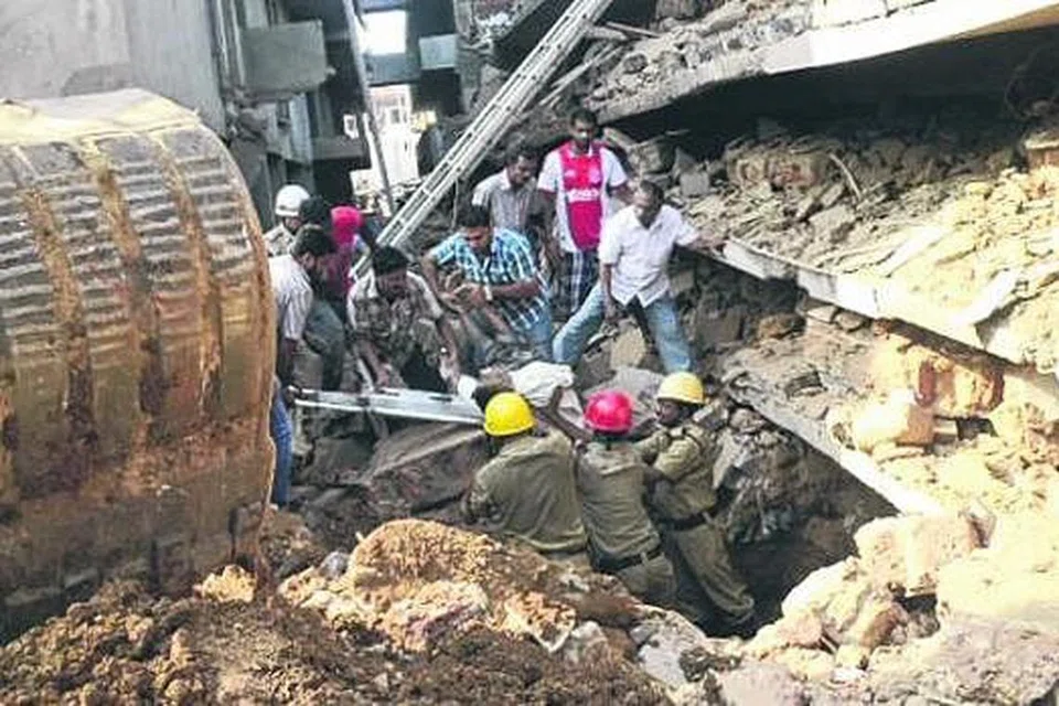 RUNTUHAN LIMA TINGKAT: Para pekerja penyelamat masih meneruskan usaha mencari mangsa yang masih terperangkap di bawah puing bangunan, semalam. - Foto AFP