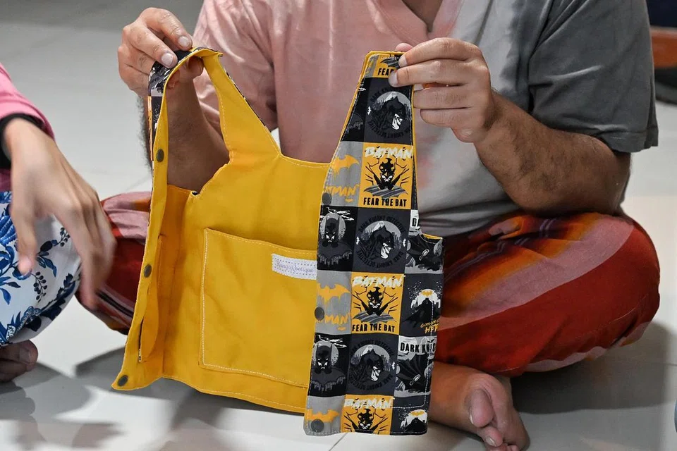 Baju ves yang dibuat khas untuk saiz bayi bagi Rafif. Baju ves itu boleh letak pek ais dalam kocek kiri  dan kanan, untuk menstabilkan suhu badan Rafif dalam persekitaran panas.