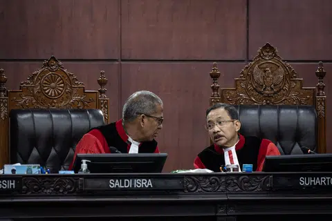 Ketua Hakim Mahkamah Perlembagaan, Dr Suhartoyo (kanan) berbincang dengan Timbalan Ketua Hakim, Profesor Dr Saldi Isra, semasa prosiding semakan kehakiman terhadap Undang-Undang Tentera Indonesia (TNI) di Mahkamah Perlembagaan, Jakarta pada 23 Jun 2025. Dalam sesi itu, Dr Saldi menyoal wakil pemerintah dan Dewan Perwakilan Rakyat (DPR) mengenai sebab pindaan undang-undang tersebut melampaui arahan mahkamah yang hanya berkaitan dengan semakan umur persaraan pegawai tentera.