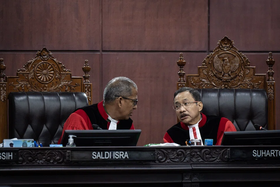 Ketua Hakim Mahkamah Perlembagaan, Dr Suhartoyo (kanan) berbincang dengan Timbalan Ketua Hakim, Profesor Dr Saldi Isra, semasa prosiding semakan kehakiman terhadap Undang-Undang Tentera Indonesia (TNI) di Mahkamah Perlembagaan, Jakarta pada 23 Jun 2025. Dalam sesi itu, Dr Saldi menyoal wakil pemerintah dan Dewan Perwakilan Rakyat (DPR) mengenai sebab pindaan undang-undang tersebut melampaui arahan mahkamah yang hanya berkaitan dengan semakan umur persaraan pegawai tentera.