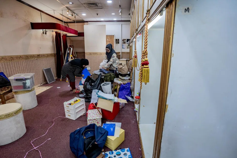 MEMBERSIH: Kakitangan dari kedai Sultanah sedang membersihkan kedai pakaian itu dan telah pun menghantar hampir 90 peratus daripada peralatan dan barang ke kedai baru di City Plaza.