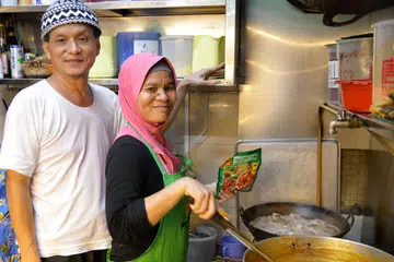 BERUSAHA BERI LAYANAN BERMUTU KEPADA PELANGGAN: Pemilik gerai Hajah Monah Kitchen, Encik Rosli Ahmad, bersama adiknya yang juga merupakan tukang masak, Cik Rohani Ahmad. - Foto SHAKIR SAIFUDDIN