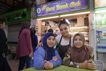 TURUN-TEMURUN: Cik Filzah (tengah) bersama ibunya, Cik Juhana Johan (kiri), dan neneknya, Cik Sahara Saini, bersemangat meneruskan perniagaan keluarga menyajikan hidangan tradisional Melayu di Geylang Serai. - Foto ALPHONSUS CHERN