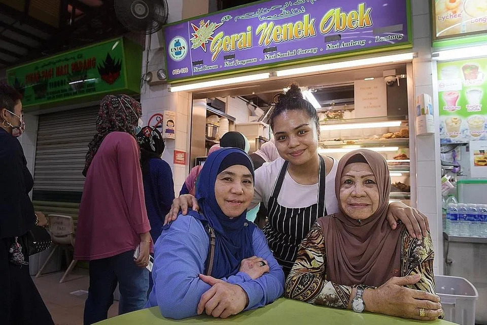 TURUN-TEMURUN: Cik Filzah (tengah) bersama ibunya, Cik Juhana Johan (kiri), dan neneknya, Cik Sahara Saini, bersemangat meneruskan perniagaan keluarga menyajikan hidangan tradisional Melayu di Geylang Serai. - Foto ALPHONSUS CHERN