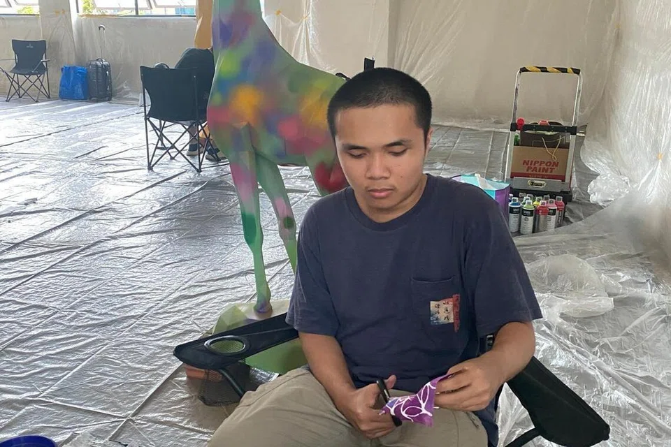 Mohammed Budiman Kamal, menyiapkan corak tompok pada bangku zirafah dengan menggunakan potongan fabrik pelbagai warna sebagai sebahagian projek seni awam GiraffeSG@Central yang dipamerkan di VivoCity.