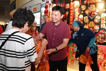 Menteri Pengangkutan merangkap Menteri Kedua Kewangan, Encik Chee Hong Tat (dua dari kanan), yang juga Anggota Parlimen GRC Bishan-Toa Payoh, mengagihkan limau kepada penduduk di HDB Hub di Toa Payoh pada 26 Januari. 