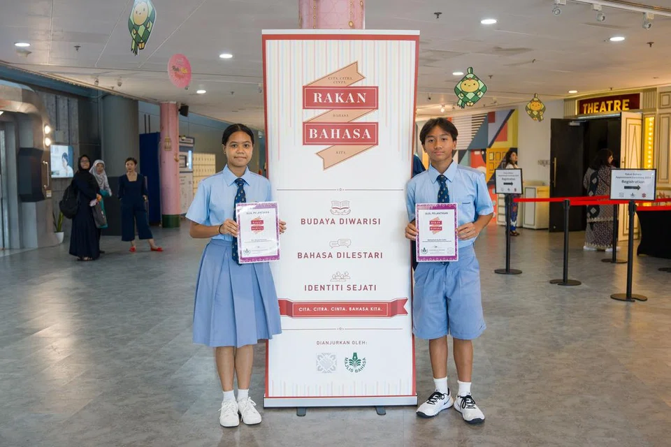 Nur Alyaa Farzana Muhammad Hafiz (kiri) dan Mohamed Aydin Saha Mohamed Khaliq (kanan), kededuanya pelajar Menengah 2 dari Sekolah Menengah Commonwealth, adalah antara 361 pelajar yang dilantik sebagai Rakan Bahasa pada 2024.