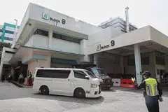MENUJU KE KREMATORIUM: Dua van putih dilihat keluar daripada rumah mayat SGH. Ini merupakan satu daripada van yang membawa mayat, yang menuju ke Krematorium Mandai. - Foto-foto BH oleh JASON QUAH