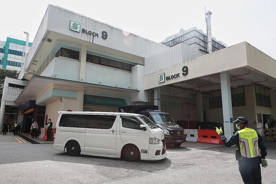 MENUJU KE KREMATORIUM: Dua van putih dilihat keluar daripada rumah mayat SGH. Ini merupakan satu daripada van yang membawa mayat, yang menuju ke Krematorium Mandai. - Foto-foto BH oleh JASON QUAH