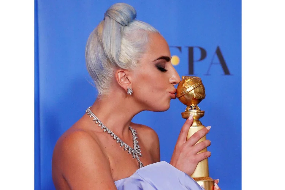 LAGU ASLI TERBAIK (FILEM): Lady Gaga mencium trofi yang dimenanginya bagi lagu Shallow dari filem A Star Is Born. - Foto REUTERS