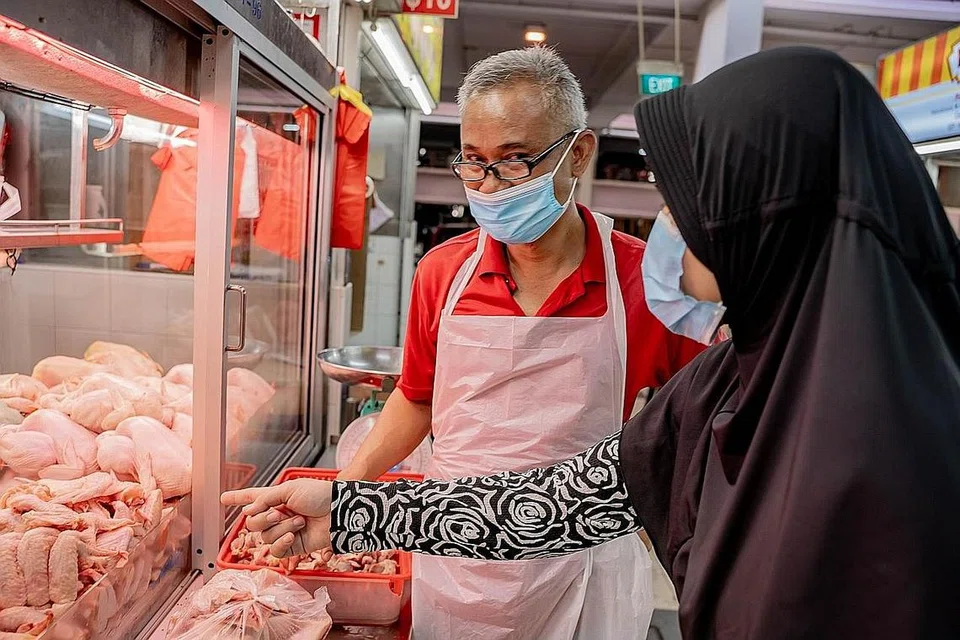 TIMBANG PILIHAN: Pemilik gerai Mohamed Ali Fresh & Frozen, Encik Husni Hashim berkata beliau akan meninjau keadaan sebelum mengambil stok ayam beku tambahan daripada pembekal lain dan menaikkan harga ayam beku yang dijual. - Foto BH oleh NUR DIYANA TAHA