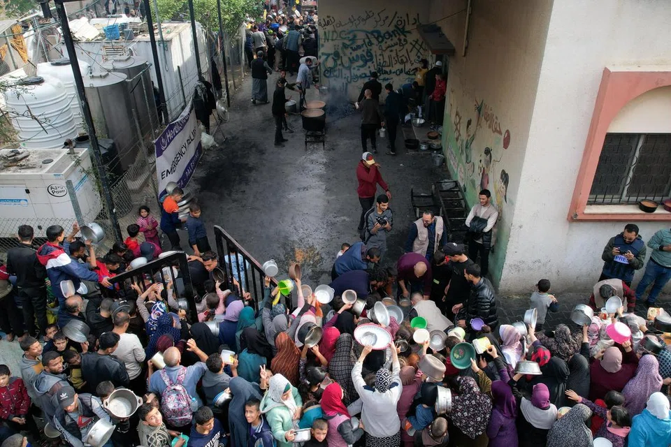 SEKAT MAKANAN: Para penduduk Palestin berasak-asak bagi mendapatkan makanan yang diagihkan oleh sebuah badan amal di Rafah, selatan Gaza pada 17 Disember.