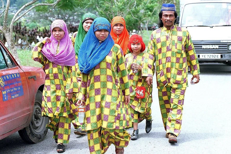 SEHATI SEJIWA: Sebuah keluarga mengenakan baju kurung sedondon bercorak kotak-kotak semasa meraikan Hari Raya Aidilfitri pada 1995.