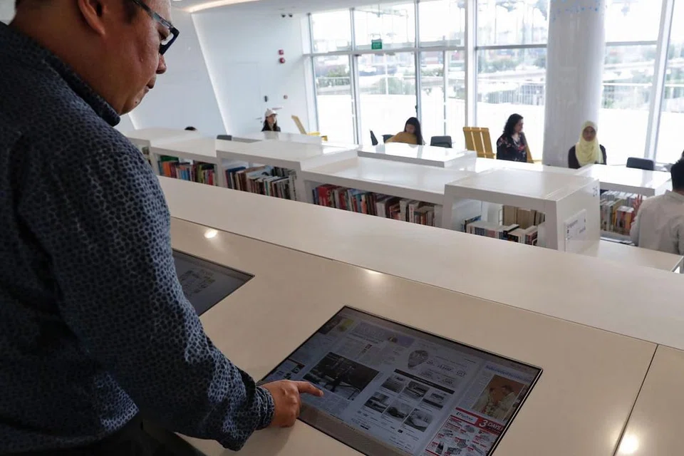 RUANG MEMBACA: Ruang membaca dalam library@harbourfront menghadap pemandangan Sentosa yang dapat dinikmati sambil pembaca membelek suratkhabar elektronik atau eNewspaper di stesen membaca eNewspaper. - Foto BH oleh KEVIN LIM