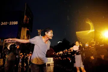 MELUAHKAN RASA TIDAK PUAS HATI: Salah seorang daripada ribuan penunjuk perasaan yang tidak mengendahkan keadaan darurat yang dikuatkuasakan melepaskan geram terhadap polis rusuhan yang dikerah meleraikan perhimpunan di jalan raya di pusat bandar Bangkok kelmarin. - Foto REUTERS