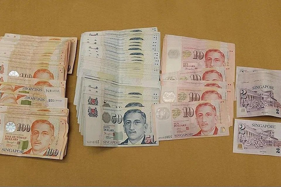 WANG TUNAI DIRAMPAS: Wang tunai berjumlah $57,929 yang dirampas dari unit kediaman di sekitar Tampines Street 83 dalam operasi CNB pada 5 Julai 2021. - Foto CNB