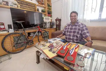 HARUMKAN NAMA NEGARA: Bermula dengan basikal yang dipinjam daripada arwah abangnya, Jamaluddin Mohamed (atas), kini berusia 55 tahun, tidak mengambil masa yang lama untuk membuktikan bakatnya yang besar dalam sukan lumba basikal apabila mendapat tempat dalam kontinjen negara di Sukan SEA sulungnya di Jakarta pada 1979. Ketika itu usianya baru mencecah 16 tahun. - Foto BM oleh IQBAL FAIZAL