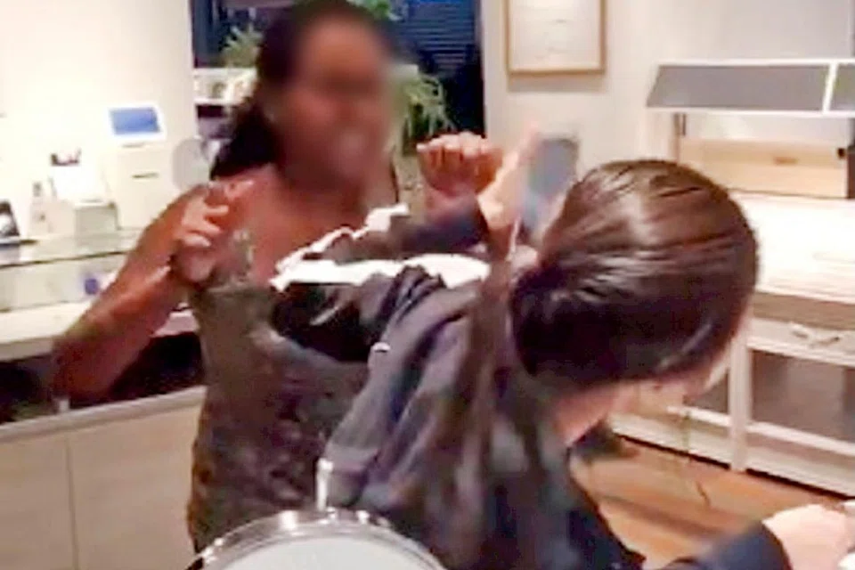 VIDEO MENULAR: Tangkap layar daripada video yang menular di Facebook ini menunjukkan seorang wanita memarahi dan memukul pekerja Owndays di Tiong Bahru Plaza. - Foto FACEBOOK