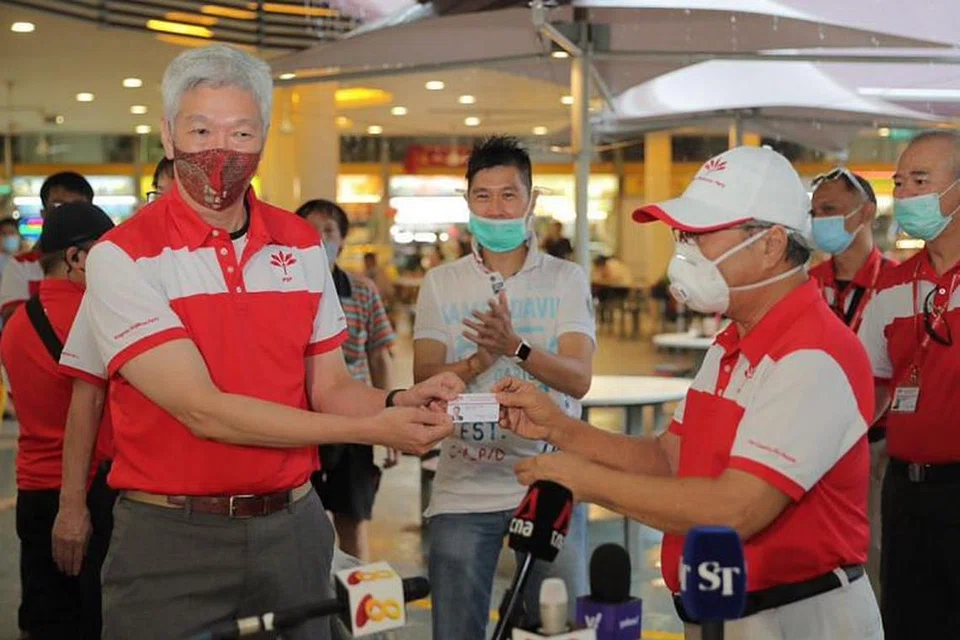 Encik Lee Hsien Yang (kiri) menerima kad keahlian Parti Kemajuan Singapura (PSP) daripada ketua PSP Tan Cheng Bock di Pasar Tiong Bahru pada Rabu.