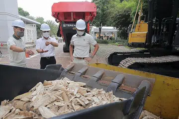 SAKSIKAN PROSES PEMUSNAHAN: (Dari kiri) CEO NParks, Encik Kenneth Er; Menteri Pembangunan Negara, Encik Desmond Lee; dan Pengarah Kumpulan Pengurusan Hidupan Liar, NParks, Dr Adrian Loo, melihat gading gajah yang telah dihancurkan oleh penghancur batu industri di Pusat Kesihatan Haiwan dan Tanam-Tanaman NParks semalam. - Foto BH oleh GAVIN FOO