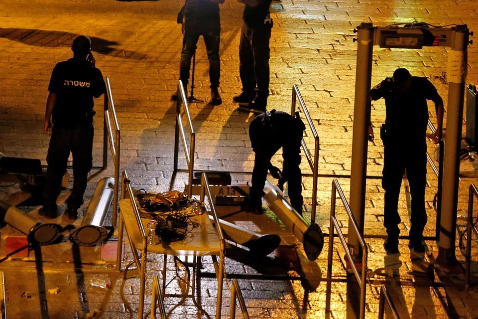 REDAKAN KETEGANGAN: Pasukan keselamatan Israel semalam menanggalkan pengesan logam yang dipasang di pintu masuk ke kawasan Masjid Al-Aqsa. - Foto REUTERS