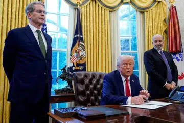 Setiausaha Perbendaharaan Amerika Syarikat, Encik Scott Bessent (kiri), dan Setiausaha Perdagangan, Encik Howard Lutnick, berdiri di sisi Presiden Amerika, Encik Donald Trump, di Rumah Putih.