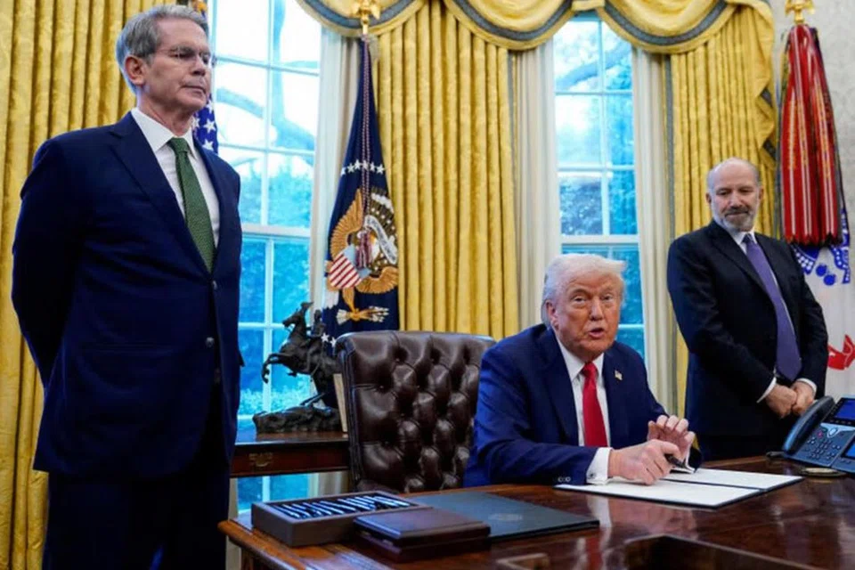 Setiausaha Perbendaharaan Amerika Syarikat, Encik Scott Bessent (kiri), dan Setiausaha Perdagangan, Encik Howard Lutnick, berdiri di sisi Presiden Amerika, Encik Donald Trump, di Rumah Putih.