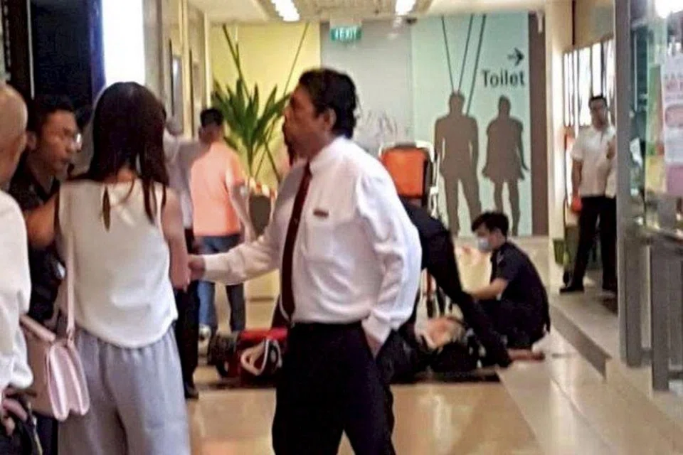DIKERUMUNI ORANG RAMAI: Orang ramai terkejut melihat lelaki yang dikatakan pengsan di luar medan selera dengan pakaiannya berlumuran darah. - Foto TWITTER