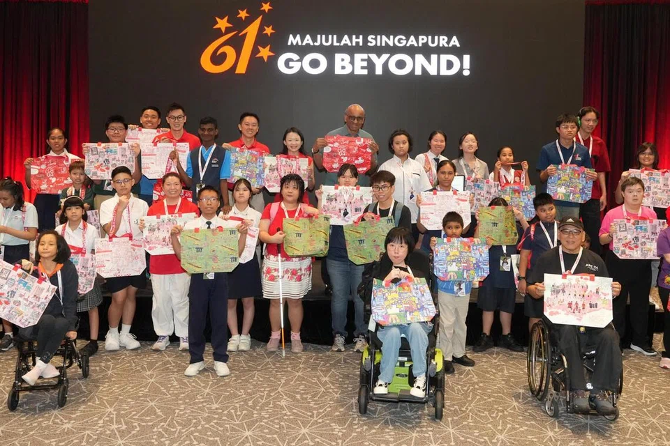 SENTUHAN KREATIVITI: Presiden Tharman Shanmugaratnam (tengah) bergambar bersama seniman berkeperluan khas yang menghasilkan enam rekaan pek sempena Hari Kebangsaan (NDP) 2026, ketika sesi bertemu dan beramah mesra di Stadium Negara pada 30 Jun. Turut hadir ialah Ketua Pegawai Eksekutif (CEO), SG Enable, Cik Lee May Gee (barisan belakang, tujuh dari kiri); Pengerusi Jawatankuasa Eksekutif NDP 2026, Brigedier Jeneral (BG) Lim Han Yong (barisan belakang, enam dari kiri); serta Pengerusi Jawatankuasa Pek NDP 2026, Leftenan Kolonel (LTC) Chong Guan Tat (barisan belakang, empat dari kiri).
