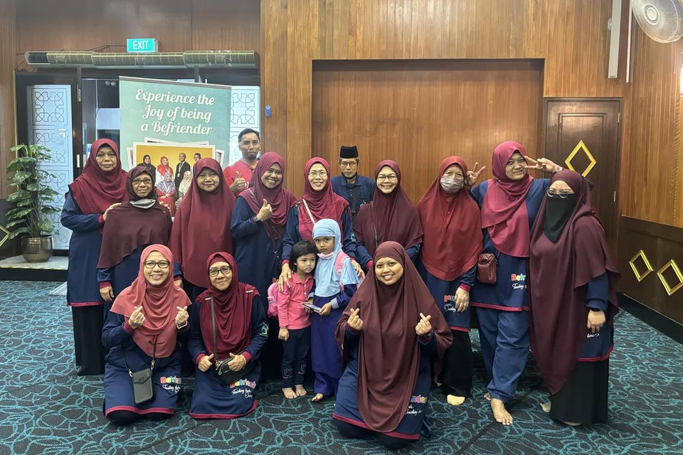 GOTONG-ROYONG: Cik Hafidzah Farof (depan, duduk paling kanan) bersama pendamping Masjid Ar-Raudhah yang membuat lawatan ke rumah penerima zakat di daerah barat.