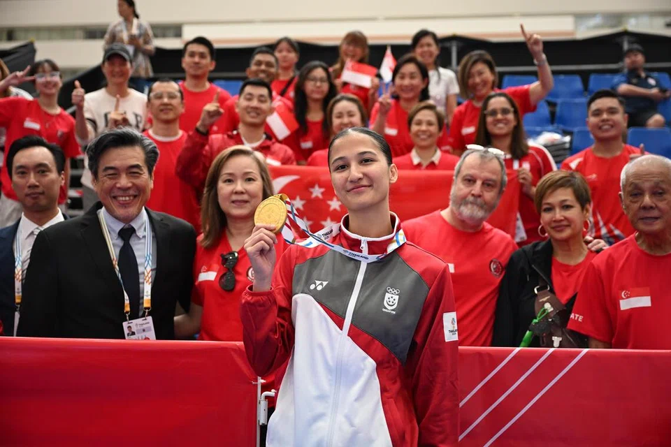 Atlet karate Singapura, Marissa Hafezan (tengah) bergambar bersama kontinjen karate dan penyokong Singapura selepas perlawanan akhir di dewan serbaguna Kompleks Kerajaan, Chaeng Watthana, di Bangkok, Thailand.