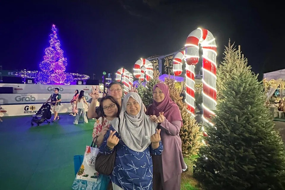 (depan, kiri) Cik Rohana Muhammad dan kawan-kawannya bersiar-siar menikmati keindahan lampu sempena Hari Krismas. 