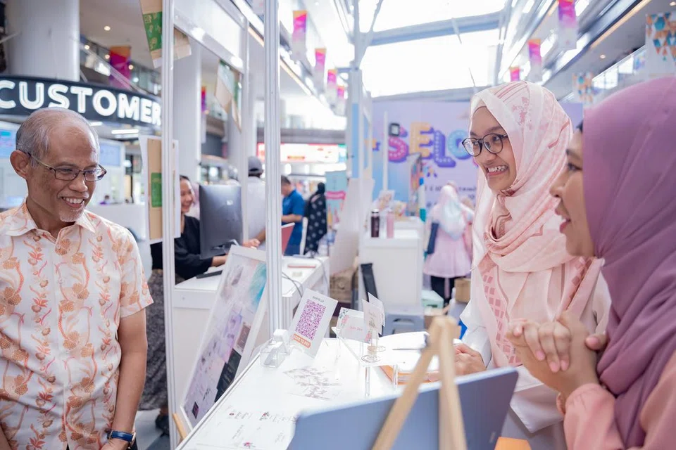 BANTU PENIAGA: Encik Masagos Zulkifli berbicara bersama pemilik Bonfaya, Cik Nadia Syaheera Mohd Asad (kiri) dan Cik Nur Faizah Abdul Jaaffar.