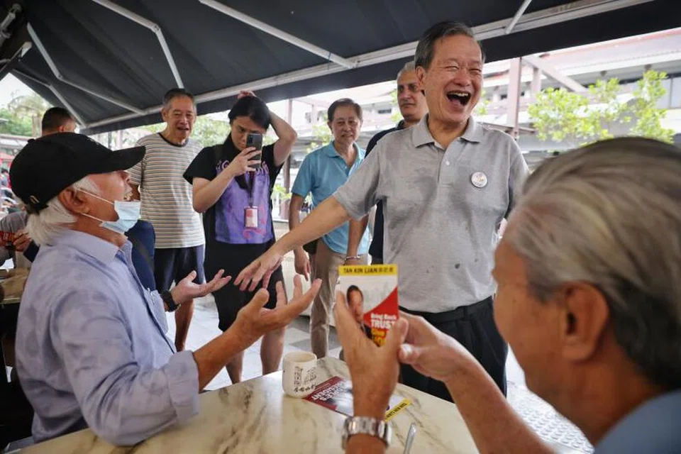 TERTAWA BERSAMA: Encik Tan Kin Lian bermesra dengan penduduk di Hougang Central pada Rabu.