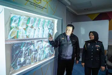 SELEWENG SUBSIDI: Pengarah Kementerian Perdagangan Dalam Negeri dan Kos Sara Hidup (KPDN) Kuala Lumpur, Encik Ariffin Samsudin, bersama Ketua Seksyen Pencegahan KPDN Kuala Lumpur, Cik Noor Azura Mohd Sharif, menunjukkan minyak masak bersubsidi yang dirampas dari dua restoran hidangan Pakistan di Kuala Lumpur pada 27 Disember.