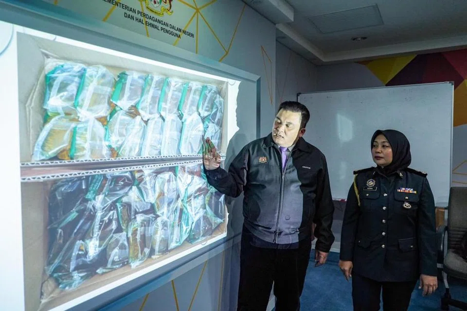 SELEWENG SUBSIDI: Pengarah Kementerian Perdagangan Dalam Negeri dan Kos Sara Hidup (KPDN) Kuala Lumpur, Encik Ariffin Samsudin, bersama Ketua Seksyen Pencegahan KPDN Kuala Lumpur, Cik Noor Azura Mohd Sharif, menunjukkan minyak masak bersubsidi yang dirampas dari dua restoran hidangan Pakistan di Kuala Lumpur pada 27 Disember.