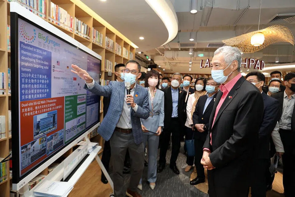 SYARIKAT SINGAPURA DI CHINA: (Kiri) Perdana Menteri, Encik Lee Hsien Loong, menyaksikan penyampaian oleh salah satu syarikat pemula Singapura, BioSyngen, semasa lawatannya ke Bandar Ilmu Guangzhou China-Singapura.
