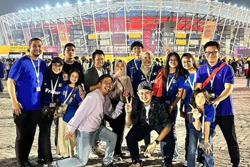 BERBALOI: Aide (kiri) bersama keluarga dan teman-teman warga Singapura yang bermastautin di Qatar untuk menonton perlawanan Piala Dunia di Stadium 974. - Foto ihsan AIDE ISKANDAR